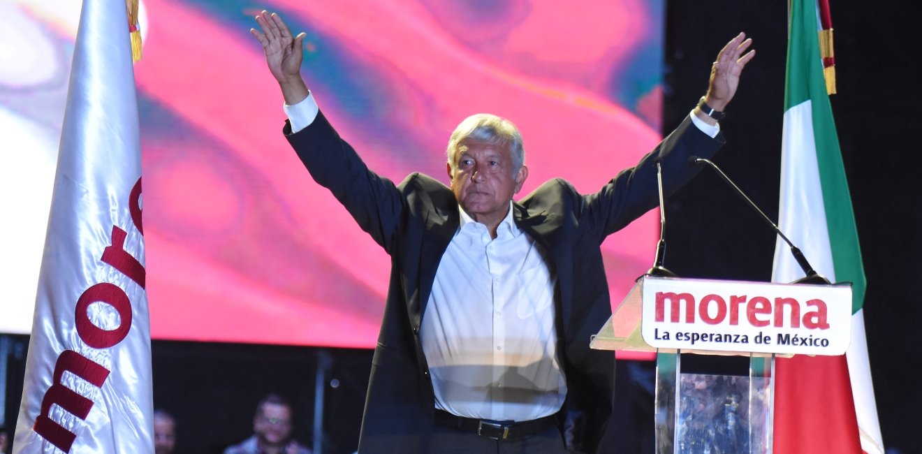 AMLO with his hands up at a Morena rally