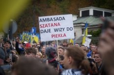 A man in Warsaw, Poland holds a sign protesting the Russian invasion of Ukraine