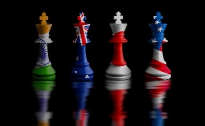 Four chess rooks with the flags of India, Australia, Japan, and the United States imprinted on them.