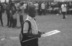 Young Nigerian boy holding a campaign sign.