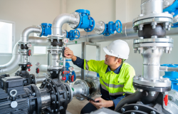 Photo of worker checking pipes at water facility