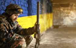 Soldier in front of Ukraine Flag