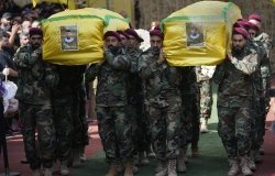 Hezbollah members carry the coffins of two of their comrades during a funeral procession in the southern suburbs of Beirut, Thursday, Sept. 19, 2024. (AP Photo/Hussein Malla)